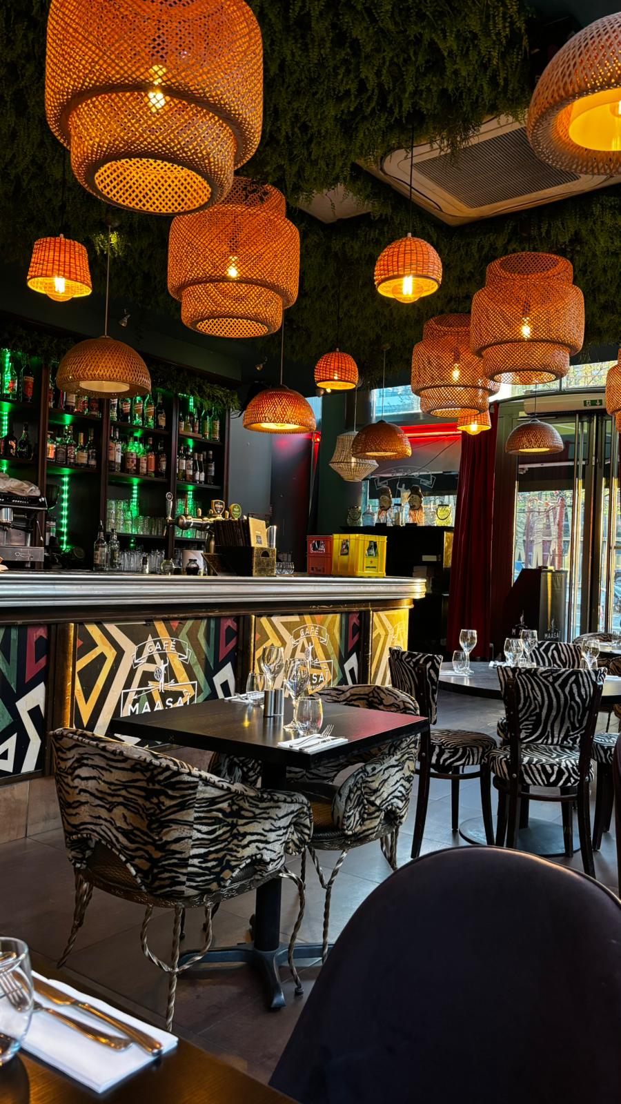 La salle et le bar du restaurant africain Le Maasaï à Paris 13 : suspensions en osier et plafond végétal